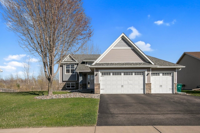 1105 Pioneer Trl SE, Cambridge, MN 55008 - view of front of property featuring stone siding, an attached garage, asphalt driveway, a front lawn, and a shingled roof