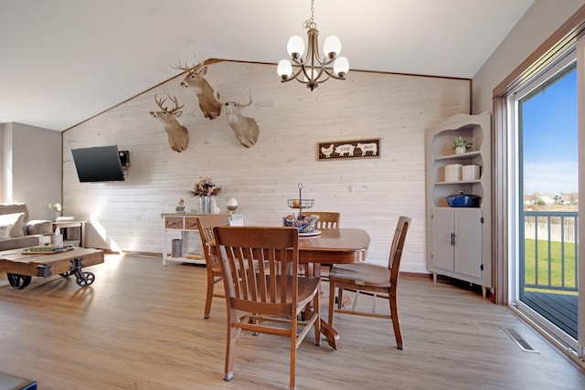 1105 Pioneer Trl SE, Cambridge, MN 55008 - dining room with vaulted ceiling, plenty of natural light, light wood-style flooring, wooden walls, and a chandelier