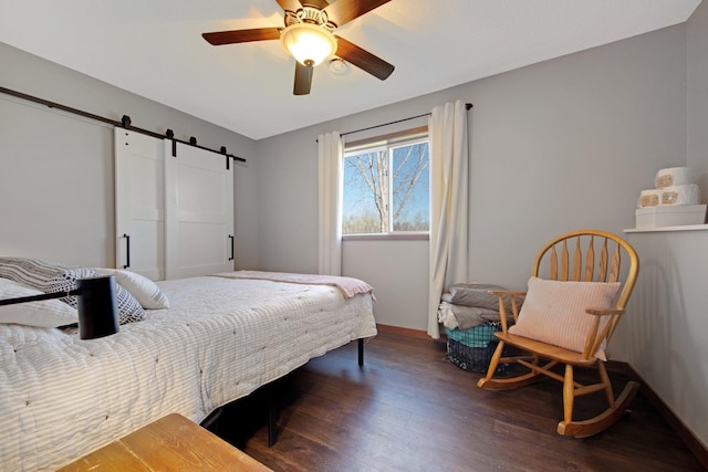 1105 Pioneer Trl SE, Cambridge, MN 55008 - bedroom featuring a barn door, dark wood-style flooring, and ceiling fan