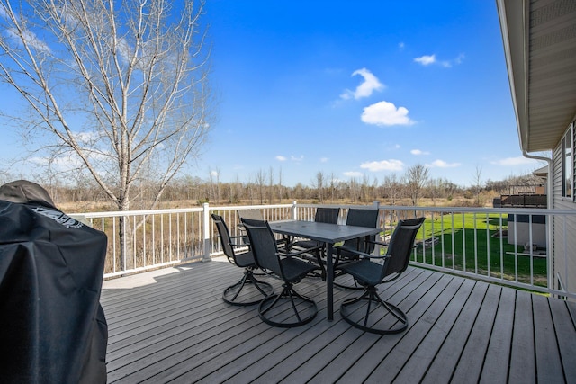 1105 Pioneer Trl SE, Cambridge, MN 55008 - wooden terrace featuring outdoor dining space and a lawn