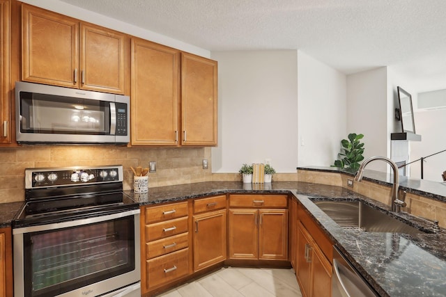 10806 Shore Dr Unit 103, Plymouth, MN 55441 - kitchen featuring stainless steel appliances, brown cabinetry, backsplash, dark stone counters, and a textured ceiling