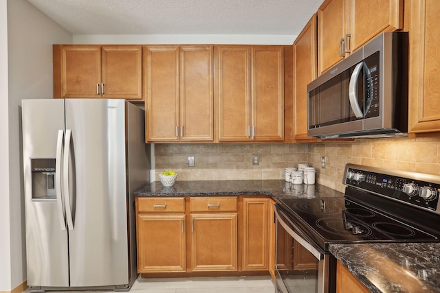 10806 Shore Dr Unit 103, Plymouth, MN 55441 - kitchen featuring stainless steel appliances, dark stone countertops, backsplash, and brown cabinetry