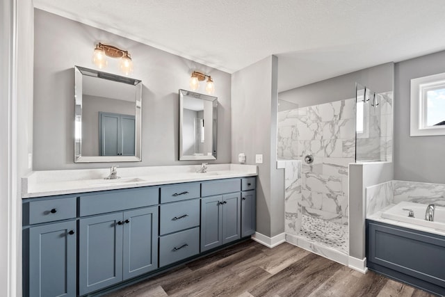 1401 142nd Ct E, Rosemount, MN 55068 - full bathroom with a bath, double vanity, a marble finish shower, a textured ceiling, and wood finished floors
