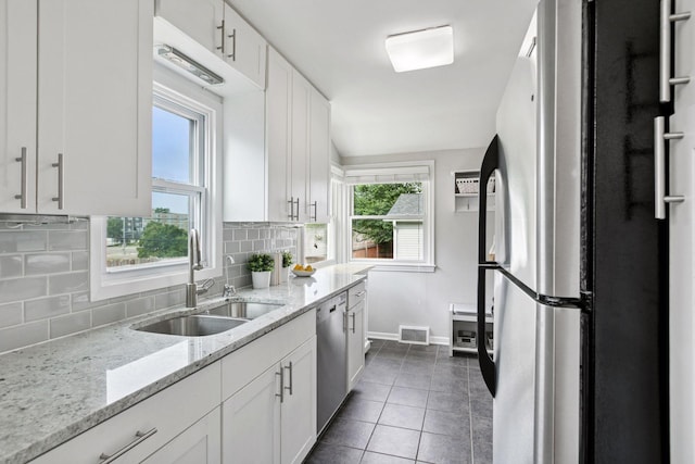 3636 Sumter Ave S, Saint Louis Park, MN 55426 - kitchen featuring freestanding refrigerator, stainless steel dishwasher, white cabinetry, and dark tile patterned flooring