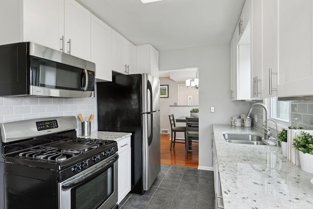 3636 Sumter Ave S, Saint Louis Park, MN 55426 - kitchen featuring stainless steel appliances, white cabinetry, backsplash, and light stone counters