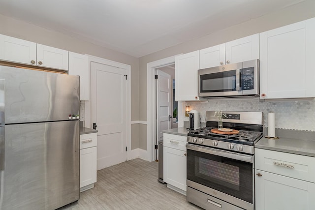 1848 James Ave, Saint Paul, MN 55105 - kitchen featuring stainless steel appliances, white cabinets, tasteful backsplash, and light wood-type flooring