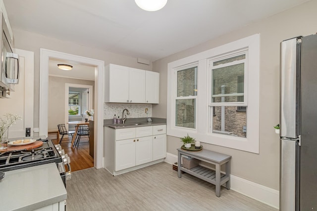 1848 James Ave, Saint Paul, MN 55105 - kitchen featuring stainless steel appliances, light wood finished floors, white cabinetry, and light countertops
