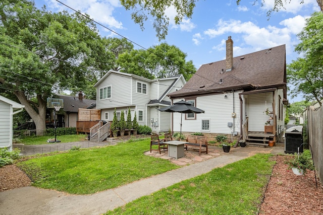 1848 James Ave, Saint Paul, MN 55105 - back of property with a chimney, a deck, a patio area, a fire pit, and a shingled roof