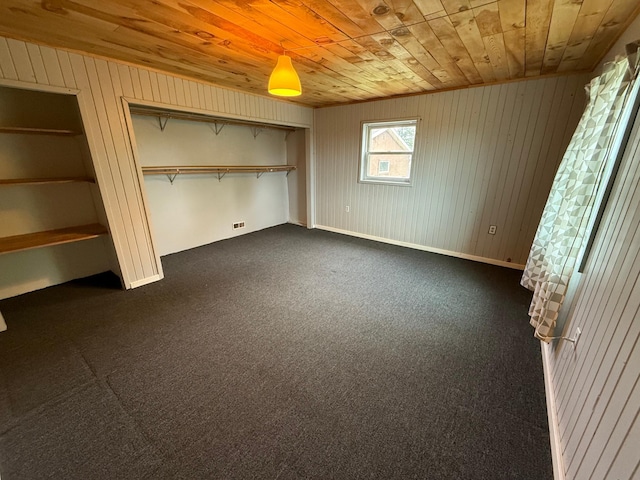 110 9th Ave NE, Deer River, MN 56636 - unfurnished bedroom with wood ceiling, wooden walls, dark colored carpet, and a closet
