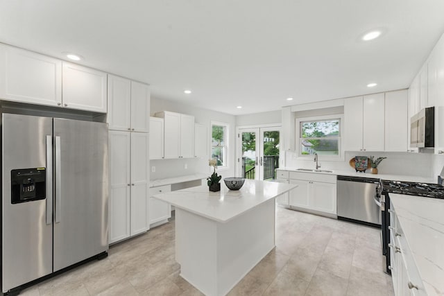 1032 Scheffer Ave, Saint Paul, MN 55102 - kitchen featuring appliances with stainless steel finishes, a sink, white cabinetry, light stone countertops, and recessed lighting