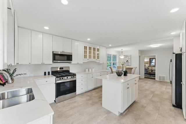 1032 Scheffer Ave, Saint Paul, MN 55102 - kitchen featuring appliances with stainless steel finishes, a sink, a center island, plenty of natural light, and recessed lighting