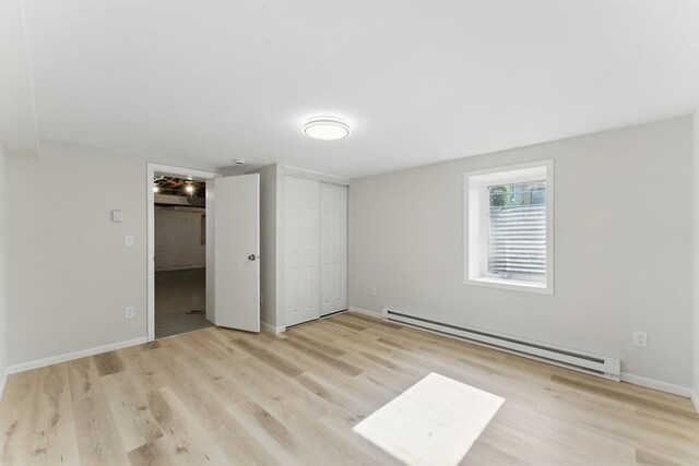 1032 Scheffer Ave, Saint Paul, MN 55102 - unfurnished bedroom with a baseboard radiator, wood finished floors, baseboards, and a closet