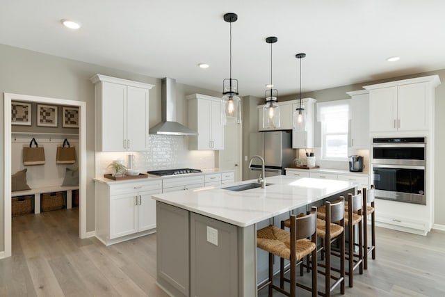 19648 104th Pl, Corcoran, MN 55374 - kitchen with wall chimney exhaust hood, appliances with stainless steel finishes, a sink, tasteful backsplash, and a kitchen bar