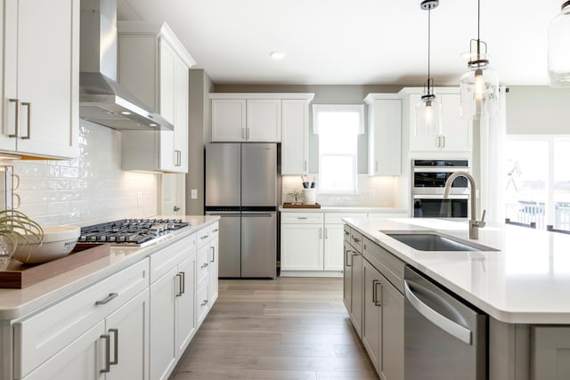 19648 104th Pl, Corcoran, MN 55374 - kitchen featuring appliances with stainless steel finishes, wall chimney exhaust hood, a sink, light countertops, and recessed lighting