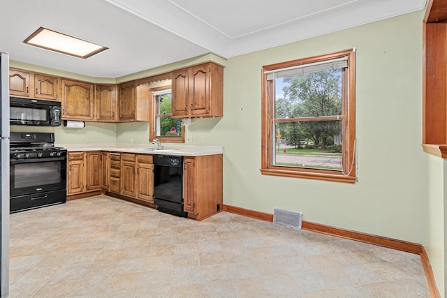 148 5th Ave N, Hopkins, MN 55343 - kitchen featuring black appliances, light countertops, plenty of natural light, and brown cabinets