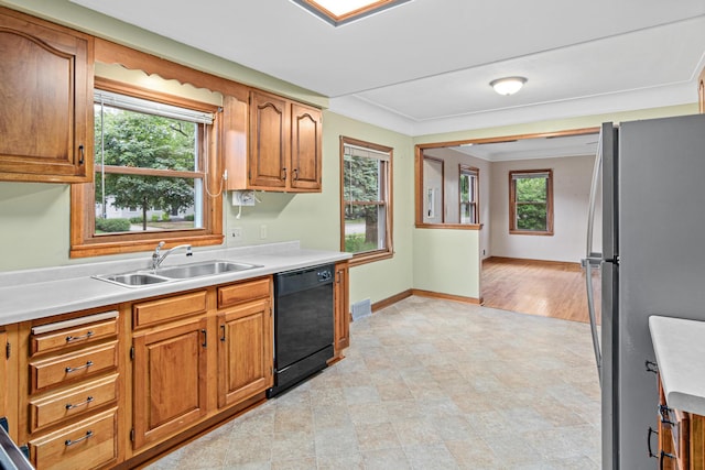 148 5th Ave N, Hopkins, MN 55343 - kitchen with black dishwasher, freestanding refrigerator, plenty of natural light, light countertops, and ornamental molding