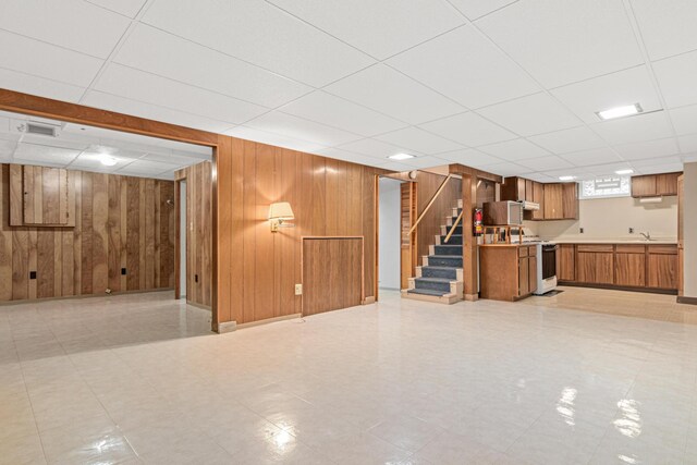 148 5th Ave N, Hopkins, MN 55343 - below grade area featuring wooden walls, stairs, a drop ceiling, and light flooring