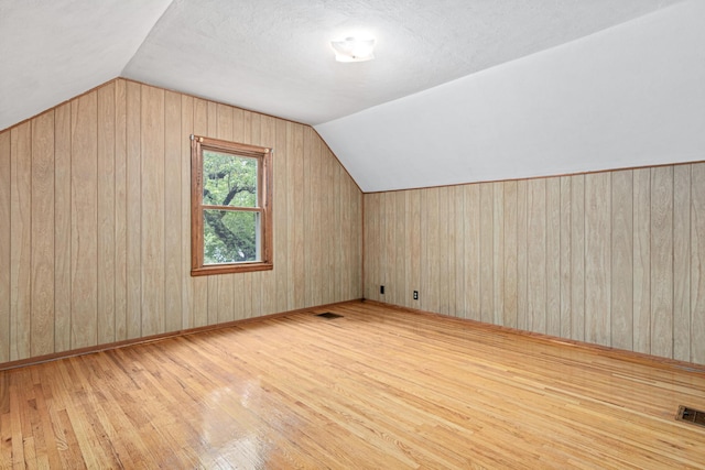 148 5th Ave N, Hopkins, MN 55343 - additional living space with hardwood / wood-style floors, wood walls, and vaulted ceiling