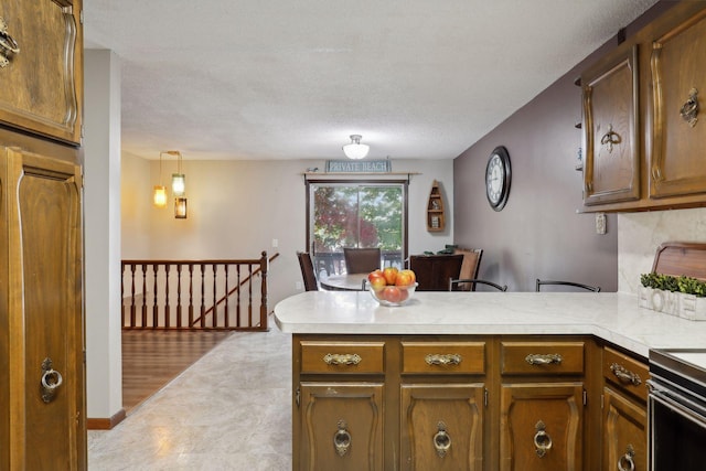 1060 Greer Ave NW, Albion Twp, MN 55358 - kitchen with a peninsula, light countertops, a textured ceiling, and brown cabinetry