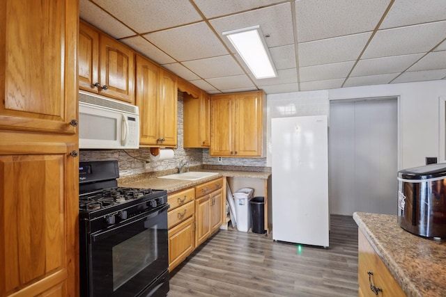 1060 Greer Ave NW, Albion Twp, MN 55358 - kitchen featuring white appliances, a sink, a paneled ceiling, light wood-style flooring, and tasteful backsplash