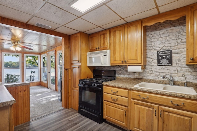 1060 Greer Ave NW, Albion Twp, MN 55358 - kitchen with white microwave, black gas range, a sink, wood finished floors, and brown cabinetry
