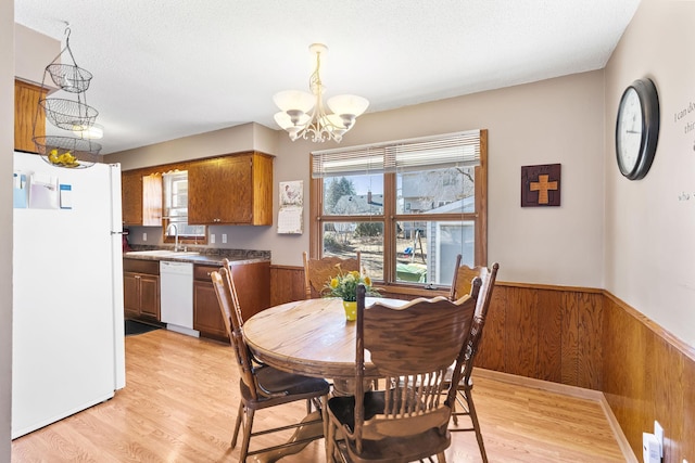 3513 Adair Ave N, Crystal, MN 55422 - dining space featuring a chandelier, wainscoting, wooden walls, and light wood-style floors