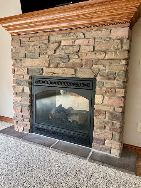 23567 Timber Trail Dr, Bemidji, MN 56601 - detailed view of a fireplace, baseboards, and carpet floors