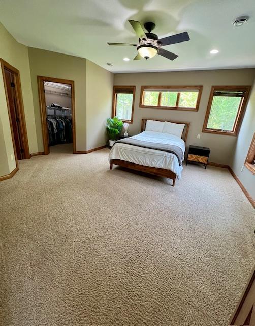 23567 Timber Trail Dr, Bemidji, MN 56601 - bedroom featuring baseboards, light colored carpet, a walk in closet, and recessed lighting