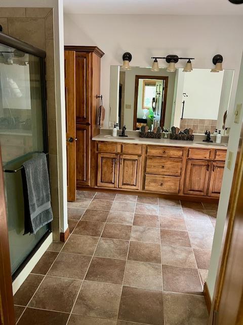 23567 Timber Trail Dr, Bemidji, MN 56601 - bathroom featuring double vanity, a shower stall, and backsplash