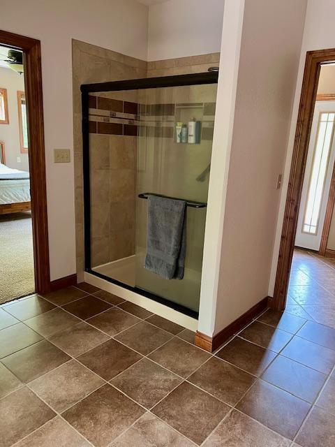 23567 Timber Trail Dr, Bemidji, MN 56601 - bathroom with baseboards, a stall shower, tile patterned floors, and connected bathroom