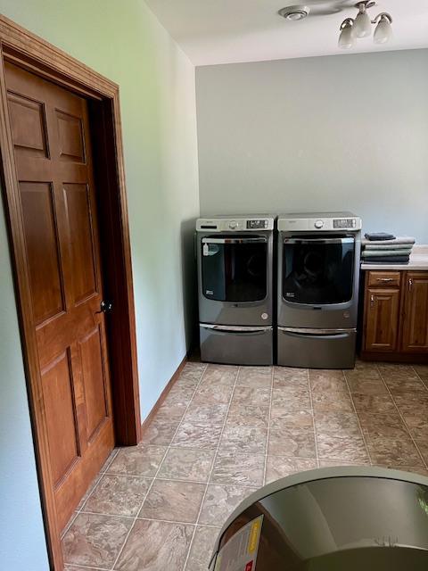 23567 Timber Trail Dr, Bemidji, MN 56601 - washroom featuring washer and dryer, cabinet space, and stone finish floors