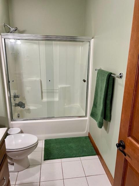 23567 Timber Trail Dr, Bemidji, MN 56601 - full bath featuring vanity, tile patterned flooring, toilet, and combined bath / shower with glass door