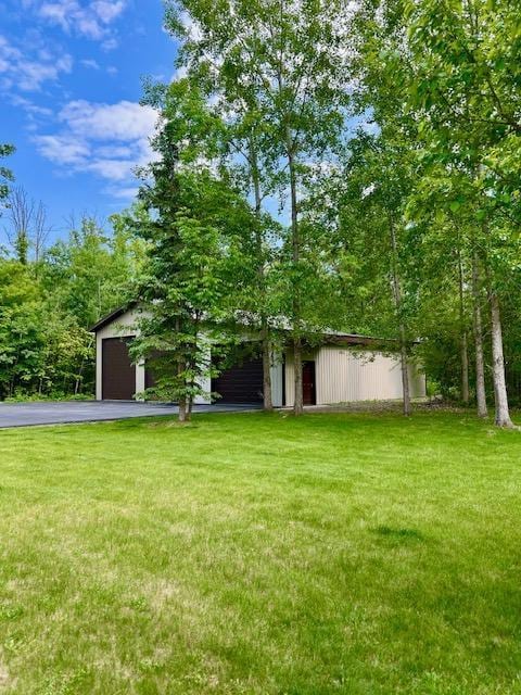 23567 Timber Trail Dr, Bemidji, MN 56601 - view of front facade featuring a front lawn, asphalt driveway, and a garage