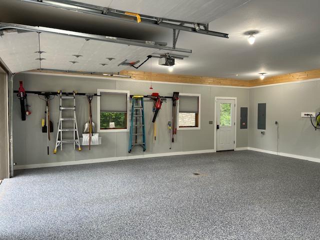 23567 Timber Trail Dr, Bemidji, MN 56601 - garage featuring electric panel, a garage door opener, and baseboards