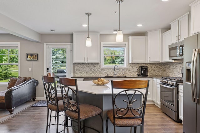 13824 102nd Pl N, Maple Grove, MN 55369 - kitchen with stainless steel appliances, a breakfast bar area, plenty of natural light, backsplash, and recessed lighting
