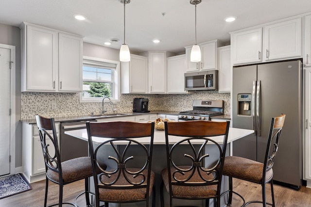 13824 102nd Pl N, Maple Grove, MN 55369 - kitchen with appliances with stainless steel finishes, wood finished floors, white cabinetry, a breakfast bar area, and recessed lighting