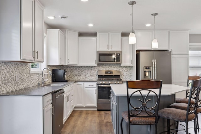 13824 102nd Pl N, Maple Grove, MN 55369 - kitchen with appliances with stainless steel finishes, a kitchen bar, white cabinets, wood finished floors, and backsplash
