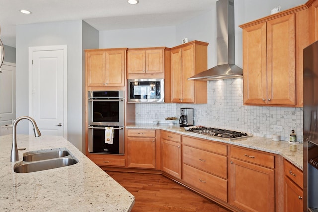 19086 100th Pl N, Maple Grove, MN 55311 - kitchen with wall chimney range hood, a sink, appliances with stainless steel finishes, decorative backsplash, and wood finished floors