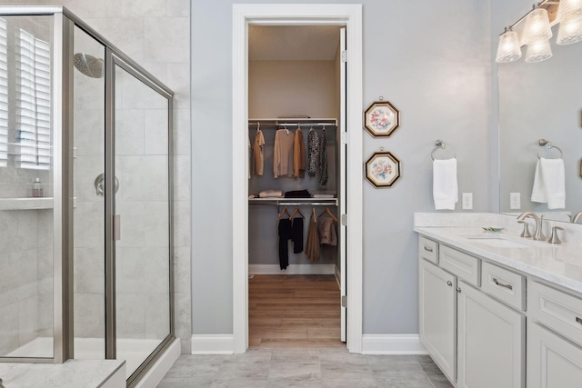 19086 100th Pl N, Maple Grove, MN 55311 - full bathroom with vanity, a stall shower, a walk in closet, and baseboards