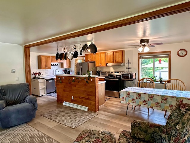 303 Goad Dr, Wrenshall, MN 55797 - kitchen with appliances with stainless steel finishes, open floor plan, light countertops, light wood-style floors, and backsplash