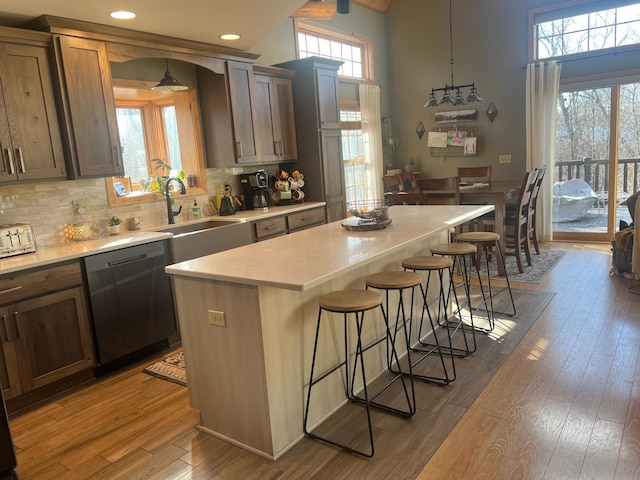 454 Wagon Wheel Dr SE Unit 17, Ten Lake Twp, MN 56601 - kitchen with dishwasher, a kitchen breakfast bar, light countertops, wood-type flooring, and decorative backsplash