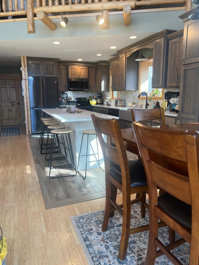454 Wagon Wheel Dr SE Unit 17, Ten Lake Twp, MN 56601 - kitchen with appliances with stainless steel finishes, a kitchen breakfast bar, light wood-type flooring, light countertops, and a kitchen island