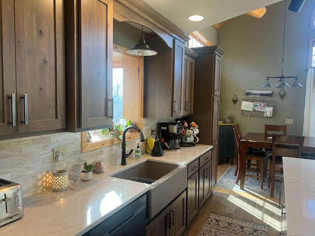 454 Wagon Wheel Dr SE Unit 17, Ten Lake Twp, MN 56601 - kitchen featuring wood finished floors, hanging light fixtures, decorative backsplash, and light stone countertops