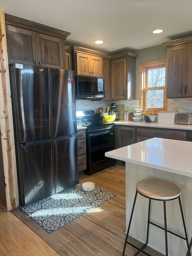 454 Wagon Wheel Dr SE Unit 17, Ten Lake Twp, MN 56601 - kitchen featuring freestanding refrigerator, range with two ovens, light wood-style flooring, a breakfast bar area, and recessed lighting