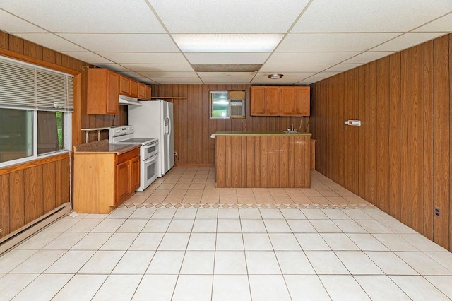 43394 Long Lake Ln, Ottertail, MN 56571 - kitchen featuring white appliances, a baseboard heating unit, wooden walls, brown cabinets, and a drop ceiling