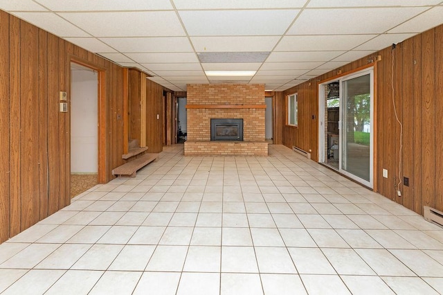43394 Long Lake Ln, Ottertail, MN 56571 - unfurnished living room featuring wood walls, a paneled ceiling, a fireplace, and a baseboard heating unit