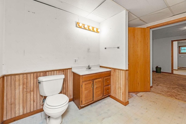 43394 Long Lake Ln, Ottertail, MN 56571 - bathroom featuring a drop ceiling, vanity, tile patterned floors, a wainscoted wall, and wooden walls