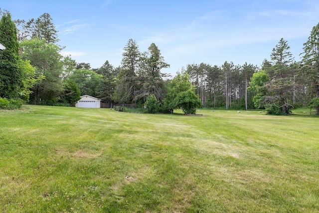 43394 Long Lake Ln, Ottertail, MN 56571 - view of green lawn with an outbuilding, a detached garage, and a forest view