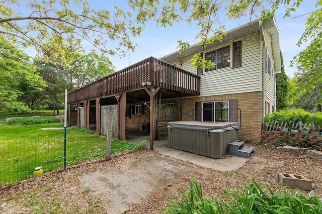 43394 Long Lake Ln, Ottertail, MN 56571 - back of property featuring a hot tub, a deck, brick siding, and a yard