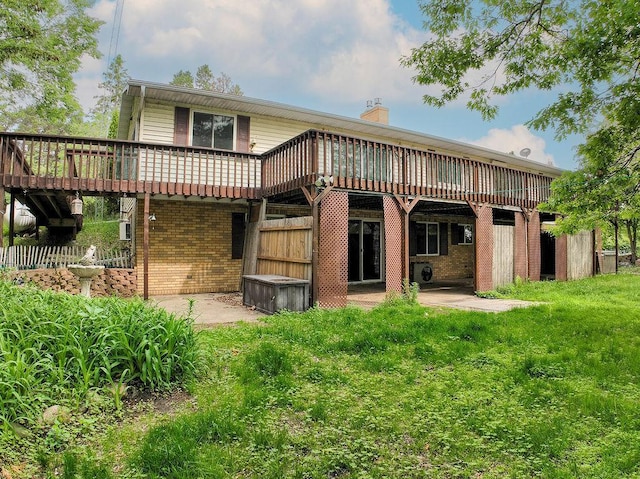 43394 Long Lake Ln, Ottertail, MN 56571 - rear view of house with brick siding, a wooden deck, a chimney, a patio, and a lawn
